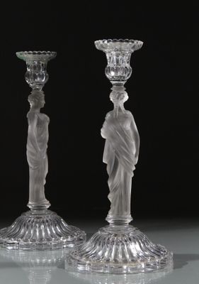 deux bougeoirs en verre transparent posés sur une table