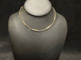 a close up of a necklace on a mannequin with a black background