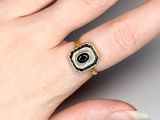 an image of a woman ' s hand with a black and white ring on it