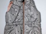 a silver vest with polka dots on it on a white wall