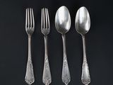 four silver spoons and a fork on a black surface