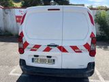 a white van with red and white stripes parked in a parking lot