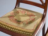a chair with a cushion on it and a chair cushion on the back of it