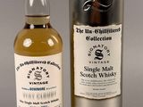 a bottle of whisky sitting next to a metal canister