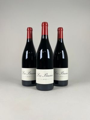 three bottles of red wine sitting next to each other on a table