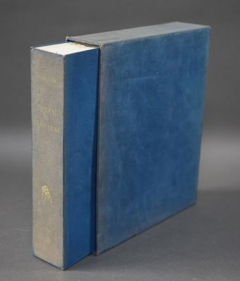 un vieux livre bleu posé sur une table près d'un mur gris