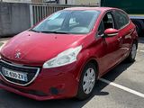 une voiture rouge garée sur un parking à côté d'un camion