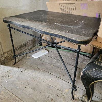 une table et une chaise dans une pièce où se trouvent des cartons par terre