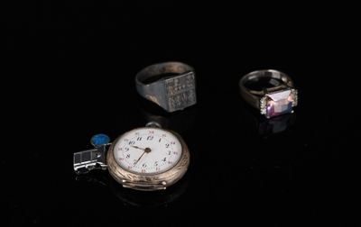 trois bagues et une montre posées sur une surface noire