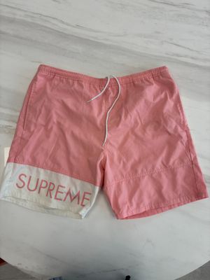 pink supreme shorts on a table next to a pair of shoes