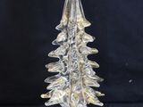 clear glass christmas tree sitting on top of a clear glass base