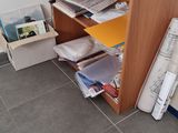 a wooden shelf with magazines and a statue on it
