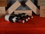 several bottles of wine sitting on top of a table next to wooden boxes