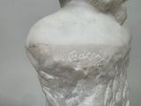a white statue of a woman with a flower in her hair