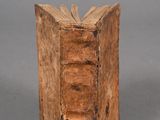 an old wooden book is sitting on a gray surface