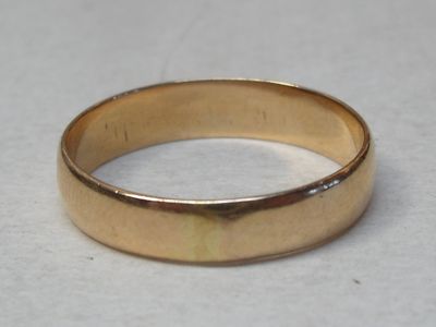 a close up of a gold wedding ring on a table