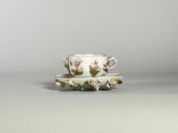 tasse à thé et soucoupe ornées de fleurs roses sur fond gris