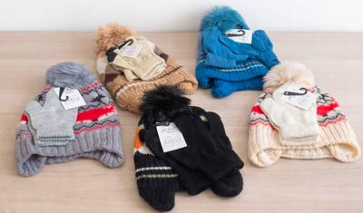 Plusieurs peluches sont alignées sur une table en bois