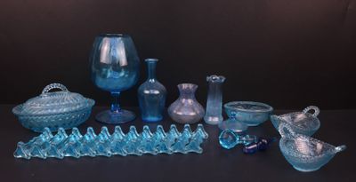 de nombreux objets en verre bleu posés sur une table