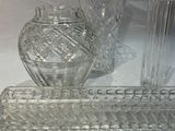 trois vases en verre et un bougeoir posés sur une table