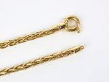 two pieces of gold chain with a clasp on a white surface