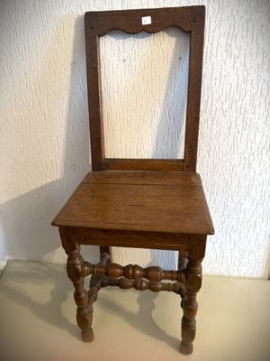 une petite chaise en bois avec une assise en bois, posée sur une table
