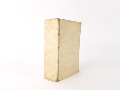 an old book sitting on top of a white table next to a white wall