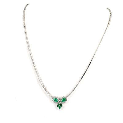 a close up of a necklace with green stones on a white background