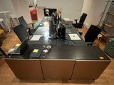 a desk with a laptop and a printer in the middle of the room