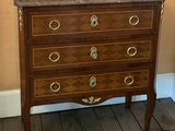 a wooden chest of drawers with a marble top