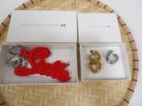 three items in a box that include a keychain, a ring, and a pair of earrings