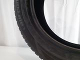 a close up of a tire on a white surface with a white curtain in the background
