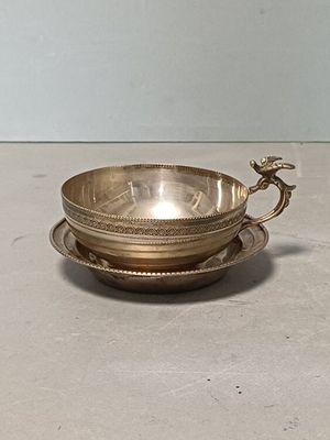 silver plated bowl and saucer on a saucer on a table