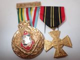 two medals and a cross on a white table