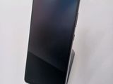the back of a black cell phone sitting on top of a white surface