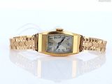 une image d'une montre-bracelet en or sur une surface blanche