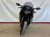a black motorcycle parked in front of a white backdrop