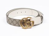 un gros plan d'une ceinture avec une boucle dorée sur fond blanc