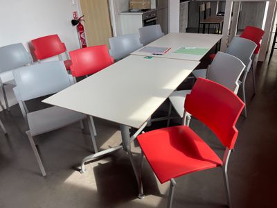 une longue table avec des chaises rouges dans une pièce