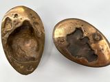 two pieces of bronze are shown on a white surface