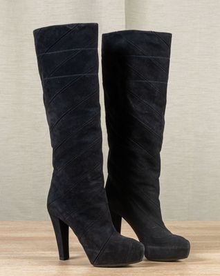 black sued high heel boots on a wooden floor