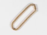 an image of a gold bracelet on a white surface