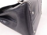 black leather purse on white background with clippings on the bottom