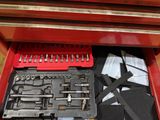 a red tool box with tools in it on the floor