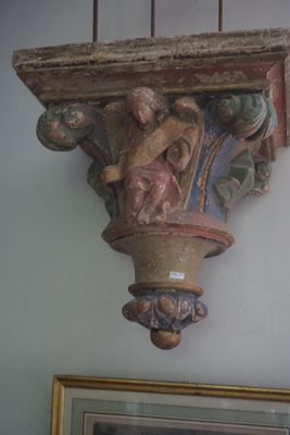 une photo d'un vase accrochée au mur au-dessus d'un tableau