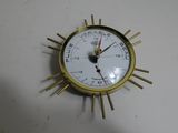 a gold clock with a white face on a white table