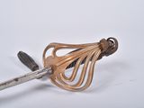 a metal whisk with a wooden handle on a white surface