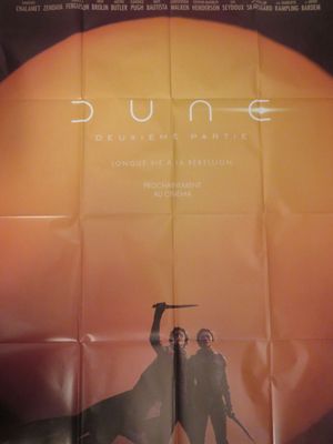 l'affiche du film « Dune », sur laquelle figurent deux hommes brandissant des épées devant un coucher de soleil
