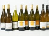 plusieurs bouteilles de vin sont alignées sur une surface blanche