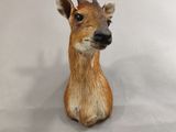 a fake deer head sitting on a white surface